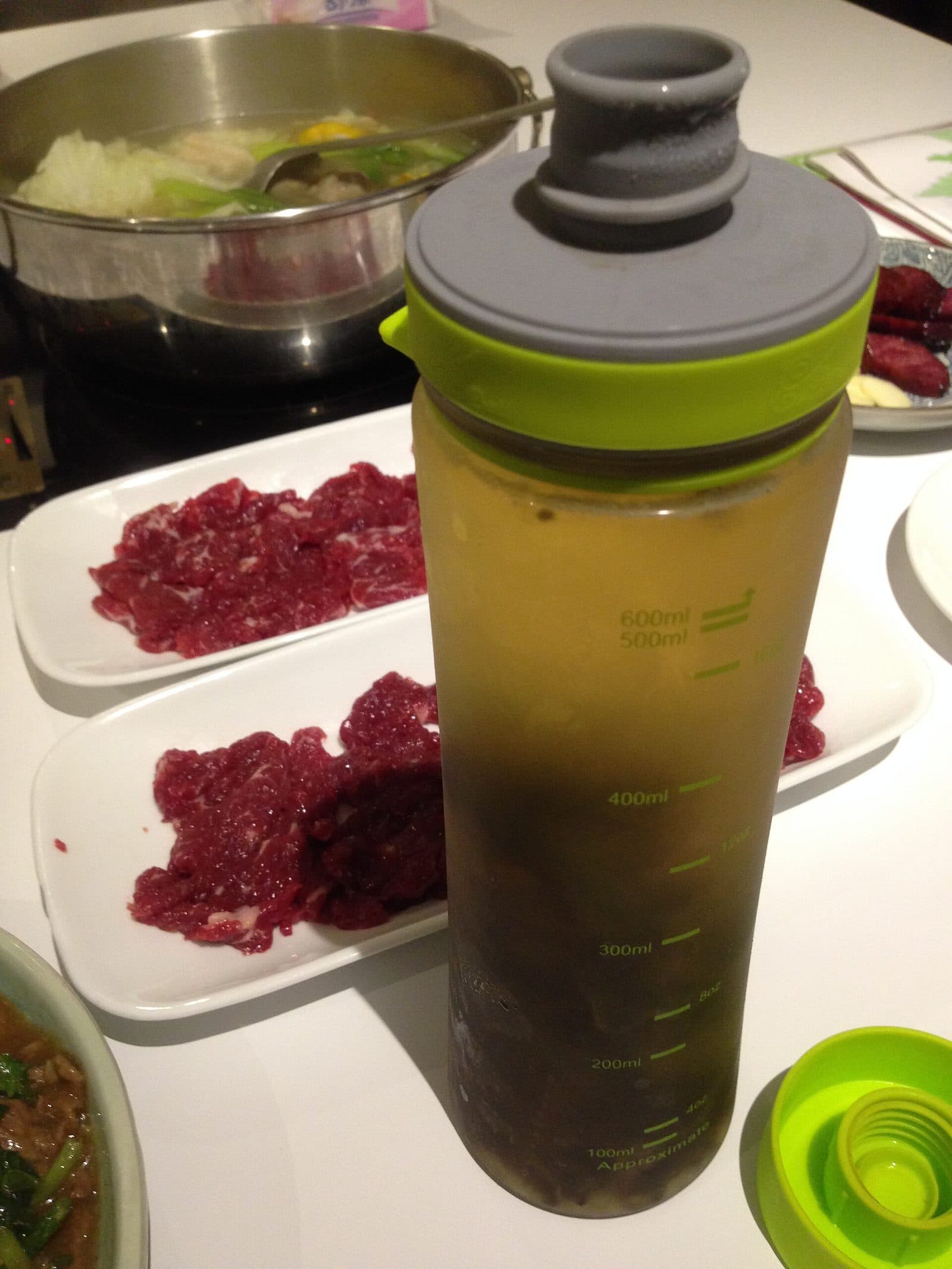 Cold-brewed green tea in a plastic infuser bottle on a restaurant table