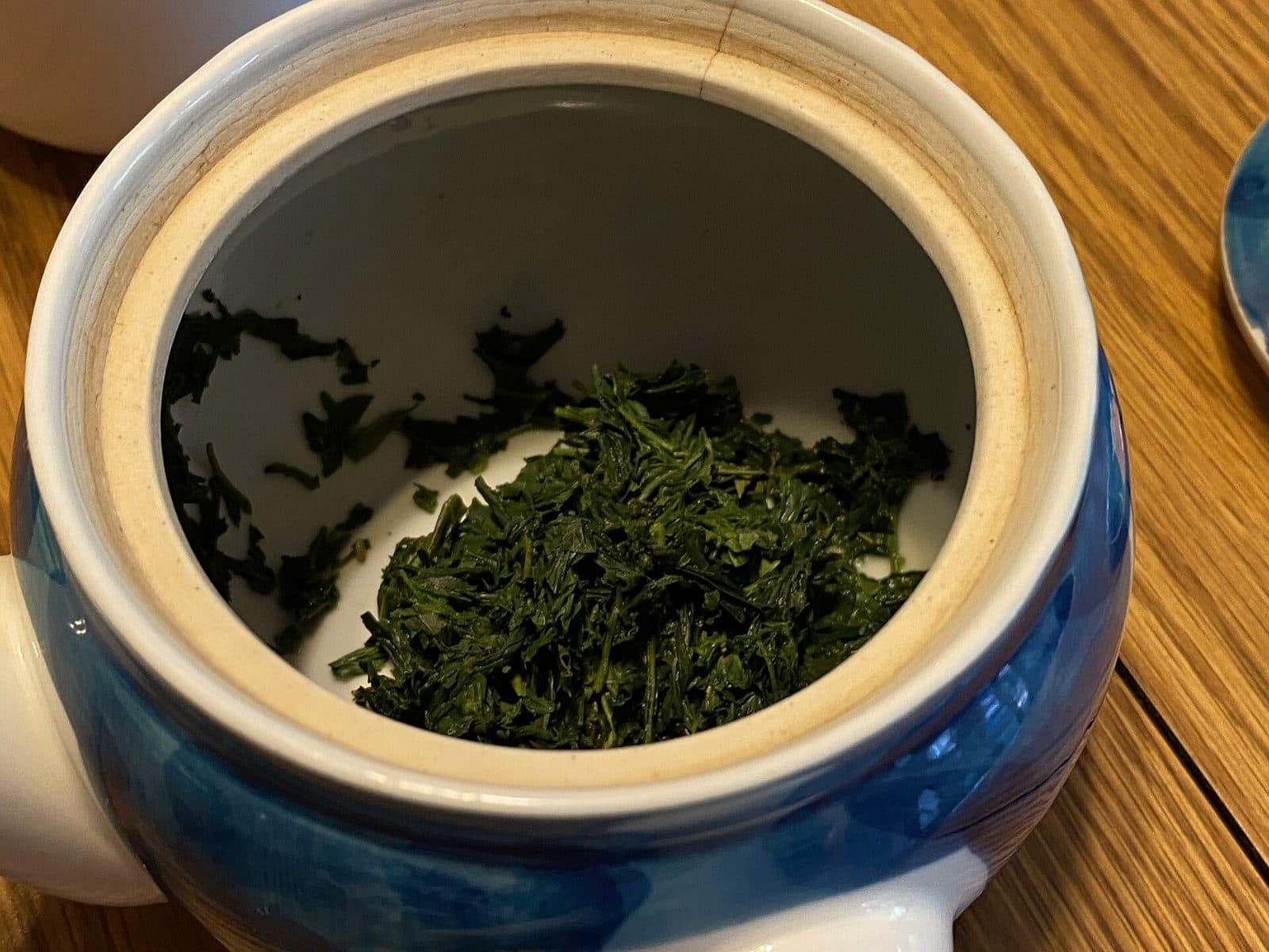 Wet, bright green gyokuro leaves inside a kyusu teapot after steeping
